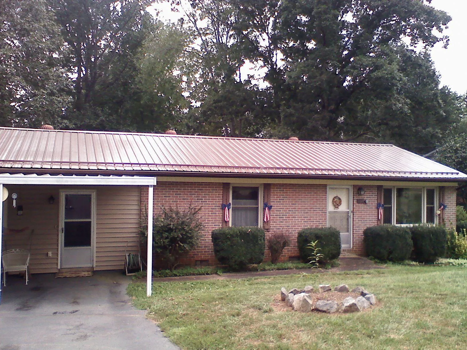 Bronze metal roof and carport on a brick ranch home — Roof Repair work by our crew in Noatak