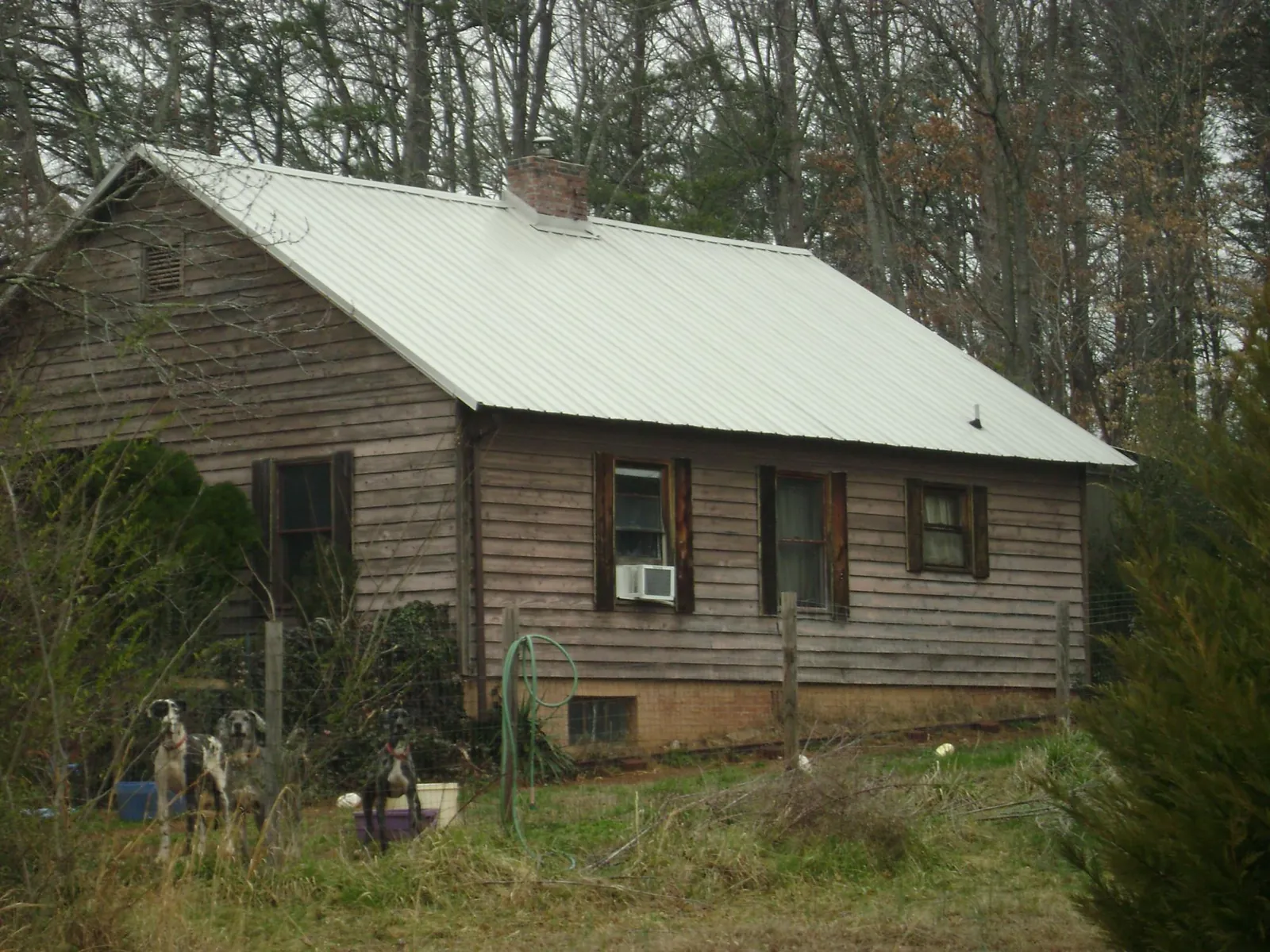 White metal roof on an old wood sided farmhouse, from a Metal Roof Installation job in Noatak